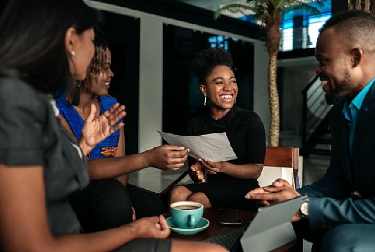 A group of people having a conversation around a table. Click to view educational resources and networking opportunities for business owners